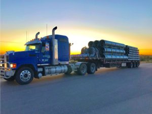 Blue truck parked with a sunset backdrop