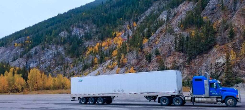 Frontier Truck on the highway with a beautiful mountain backdrop.